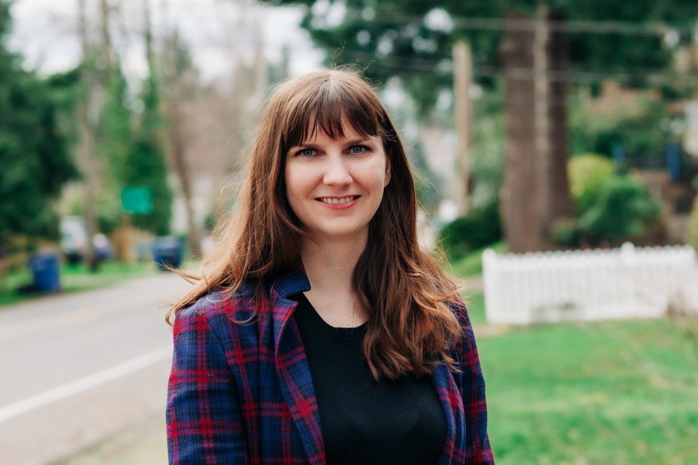 A portrait of Leah Griffin, smiling towards the camera, standing in a suburban neighborhood.