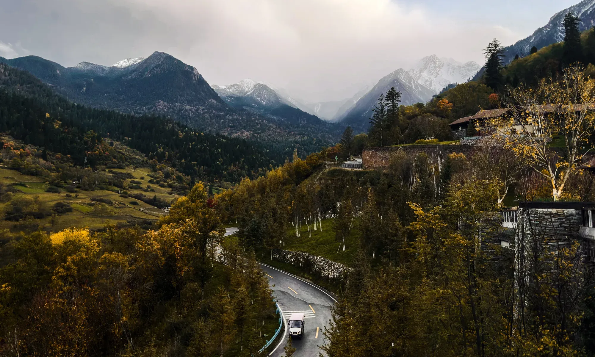 Jiuzhaigou valley vista showing winding mountain paths and golden agricultural landscape integrated with natural topography, by WLTravelbook