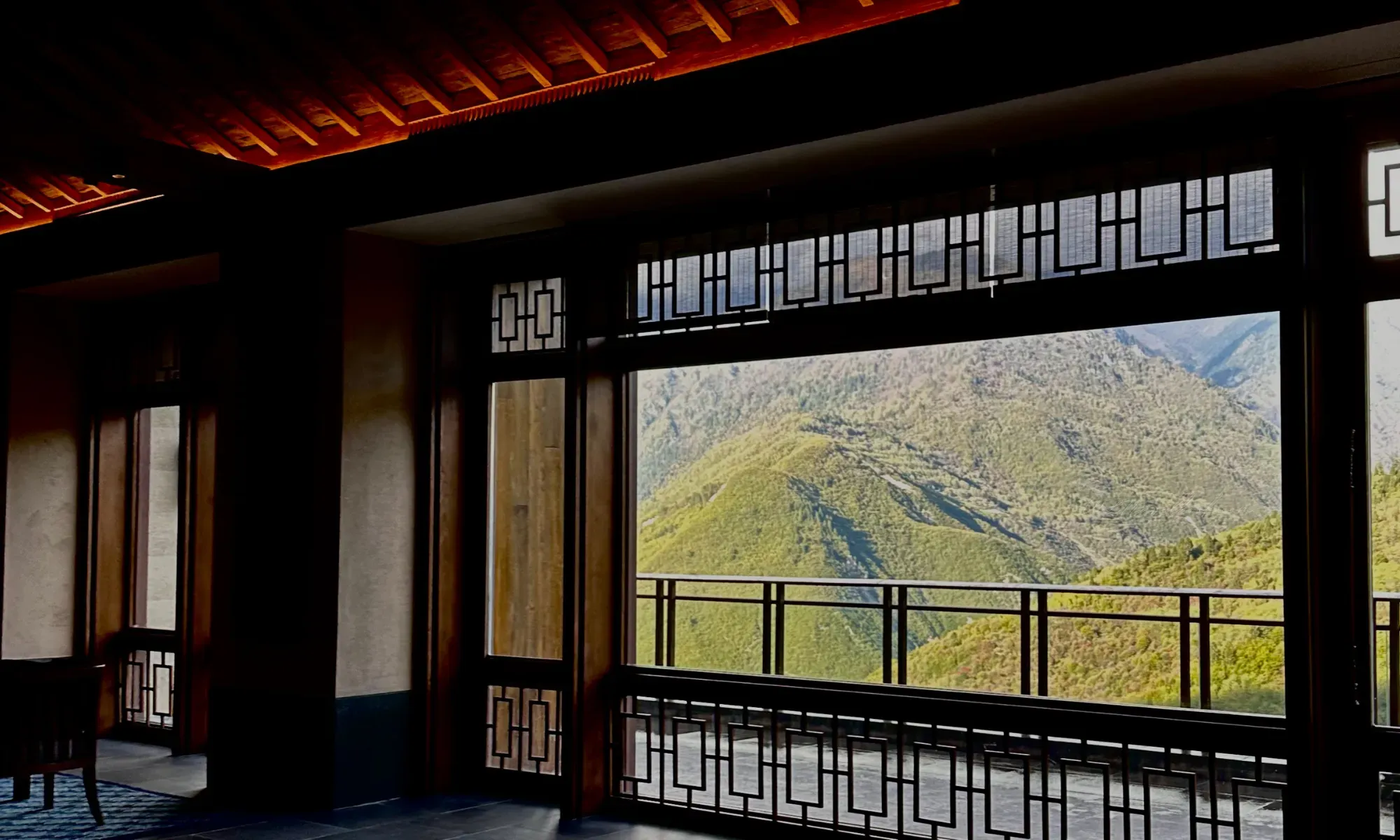 Rissai Valley interior railing framing mountain view, demonstrating architectural restraint and natural landscape integration, by WLTravelbook