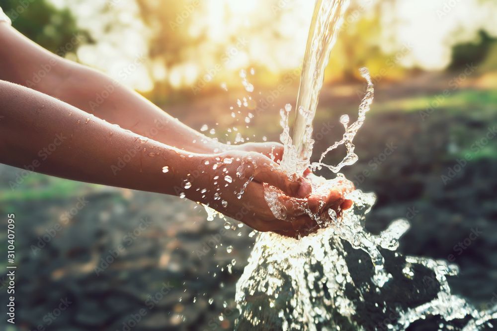 Water pouring on hand in morning ligth background