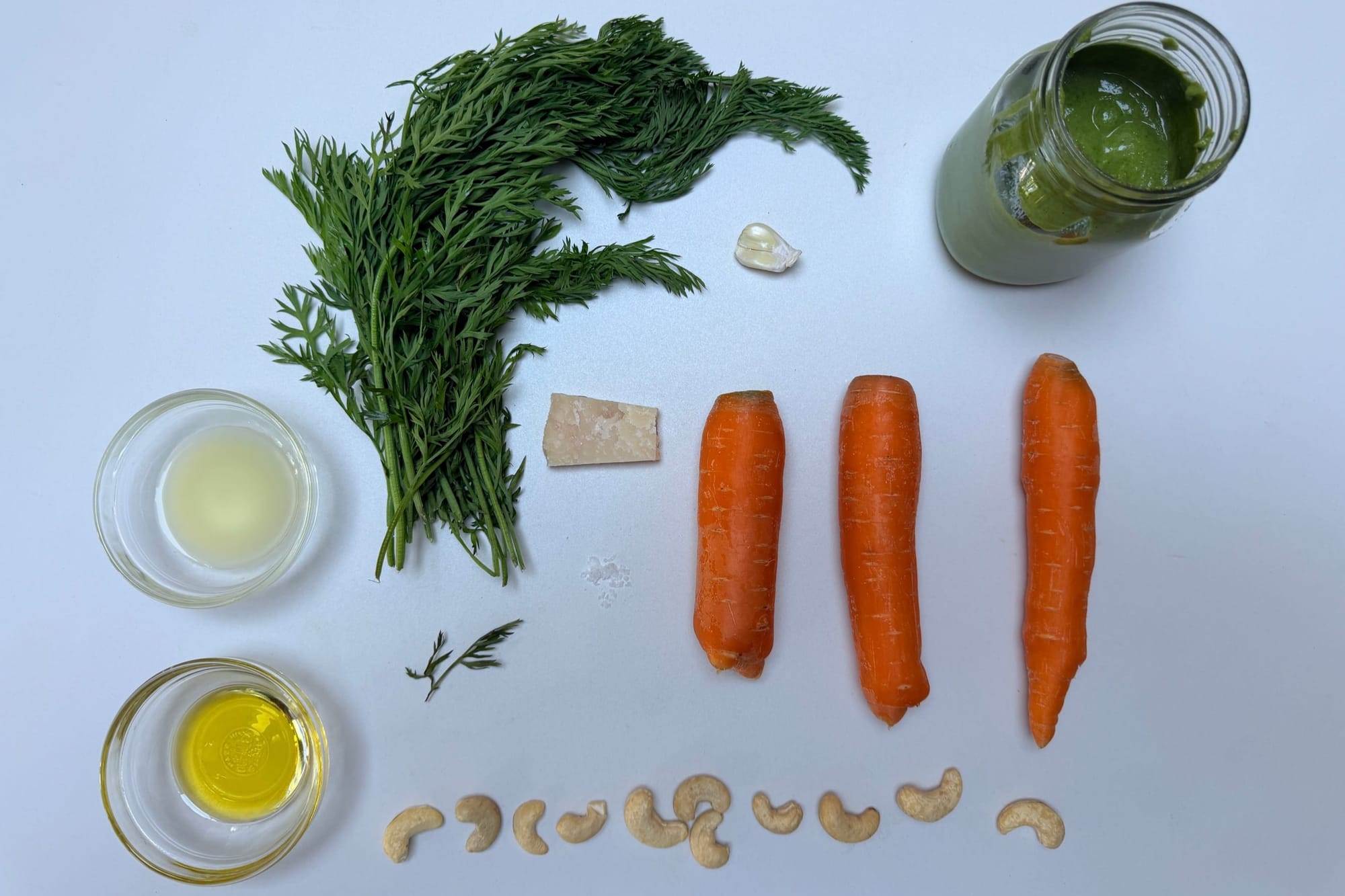 Ingredients lay out for carrot top pesto (plus a few orange carrots for color).