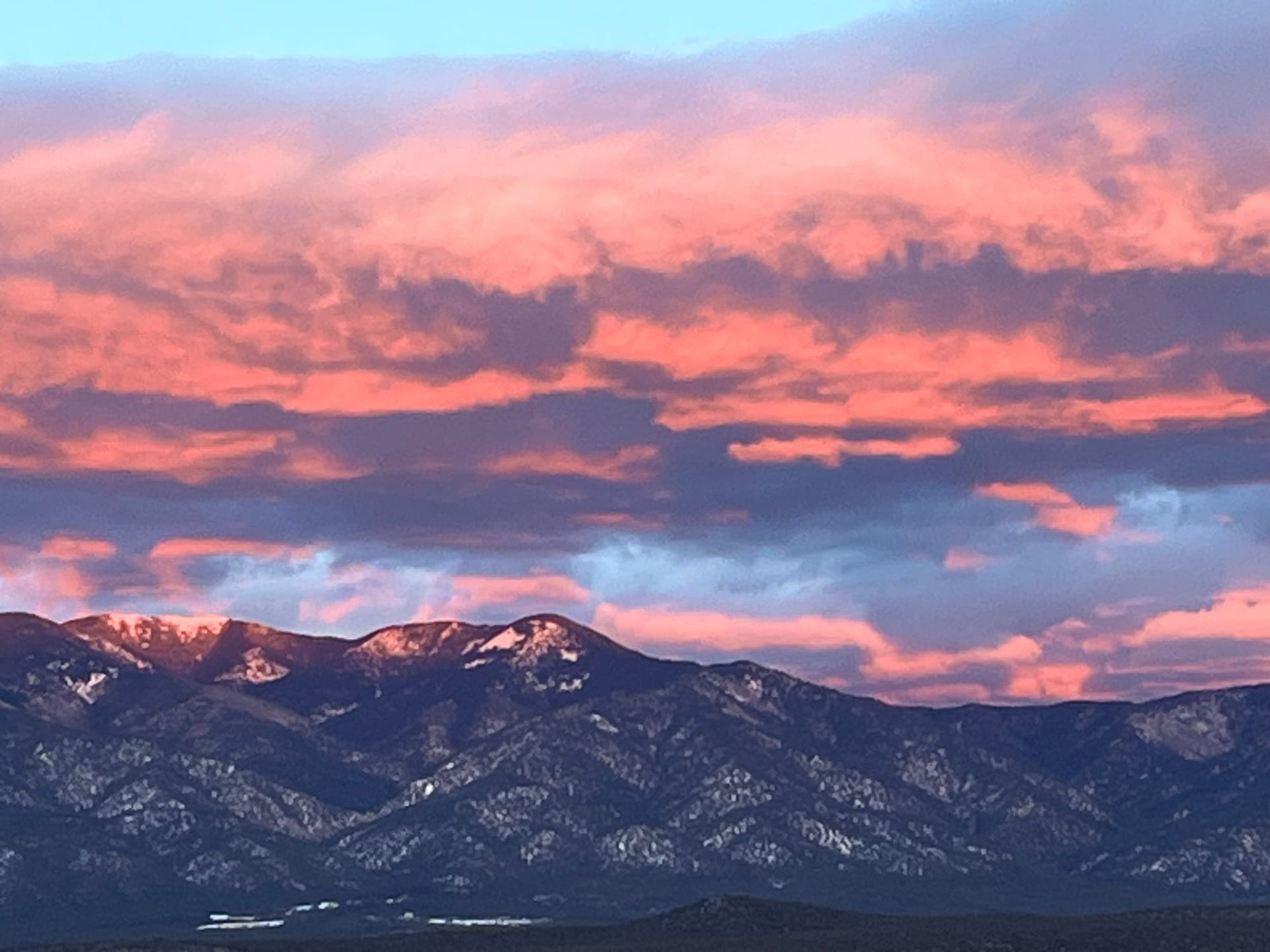 Pink and blue sunset over snow-capped mountains in Taos, NM