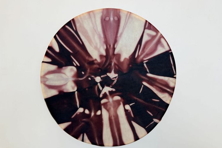 A handmade, black walnunaturally-dyed deerskin drum