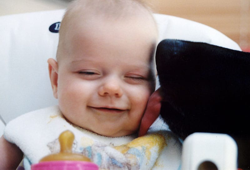 Baby smiles when licked by the family dog