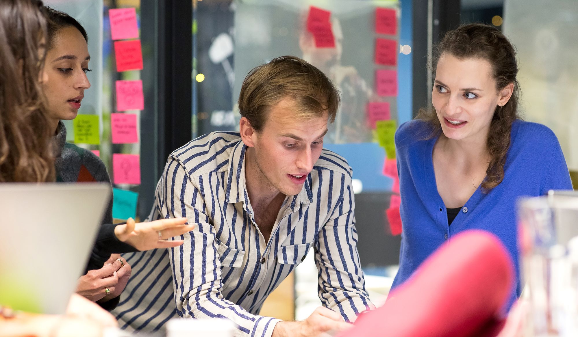 Vier mensen in discussie in een kantooromgeving