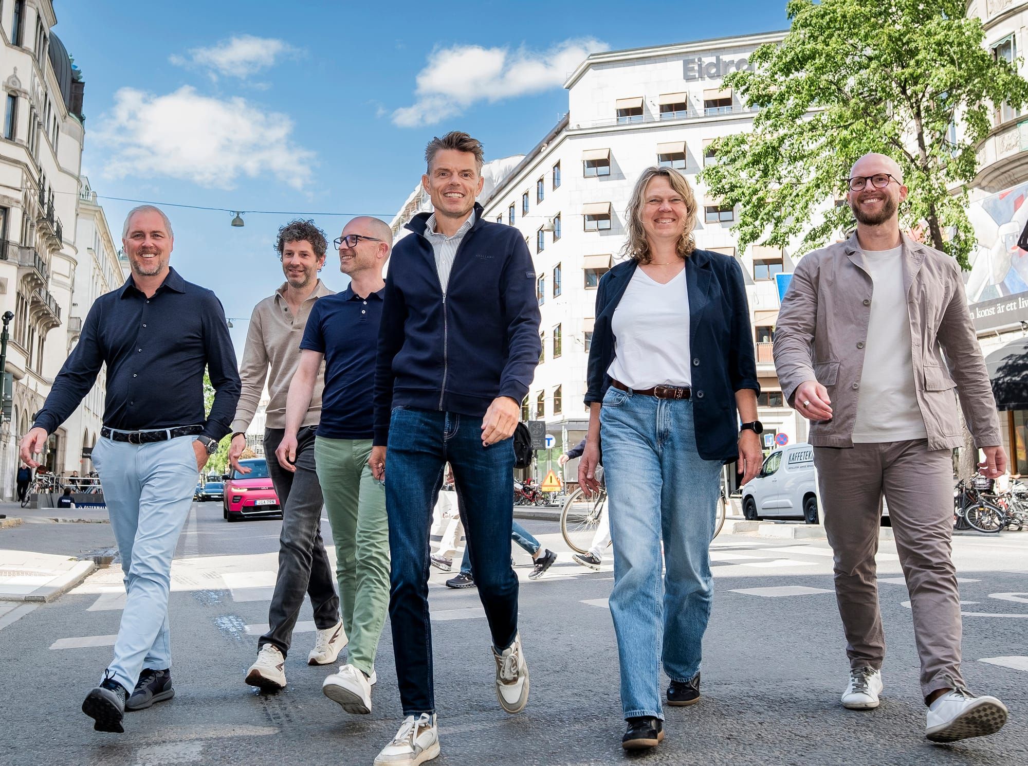 Vier mannen en een vrouw die op straat wandelen in Stockholm.