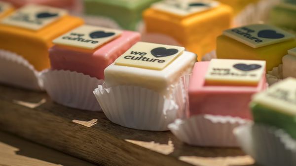 Gebakjes met verschillende kleuren waarom de tekst staat "we love culture".