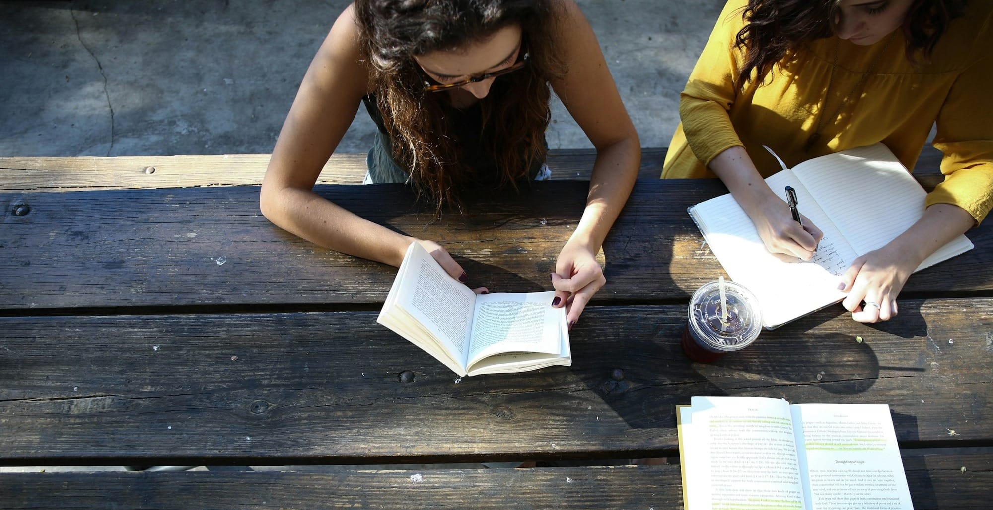woman reading book while sitting on chair
