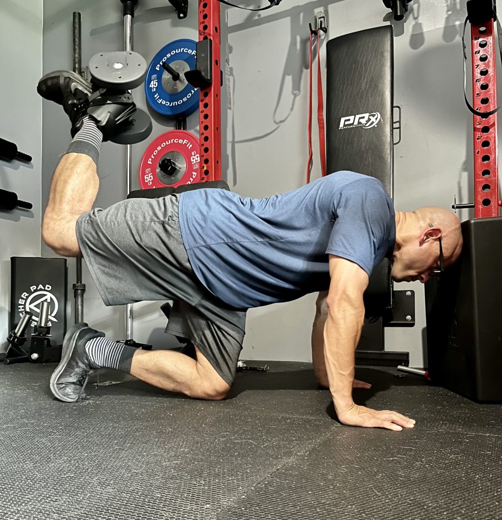 A person performing monkey feet exercise, targeting the core and upper body muscles.