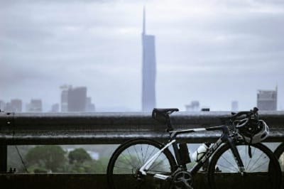 a bicycle parked on a bridge with a city in the background