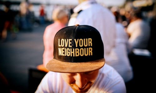 man wearing black cap with love your neighbour print during daytime