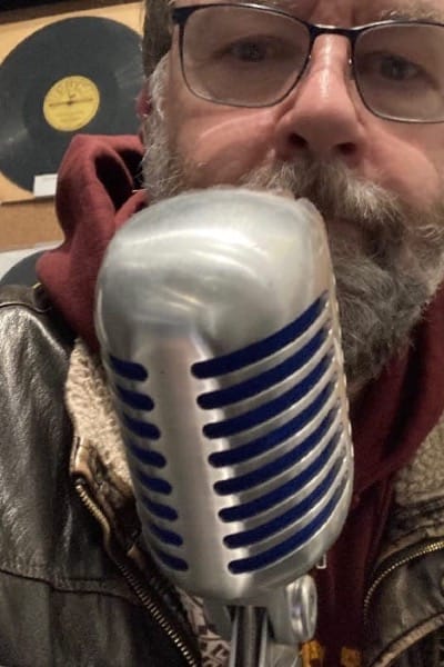 The face of DJ Tom Jackson behind a mic