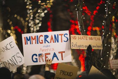 Immigration protest signs being held up by protesters at a rally.