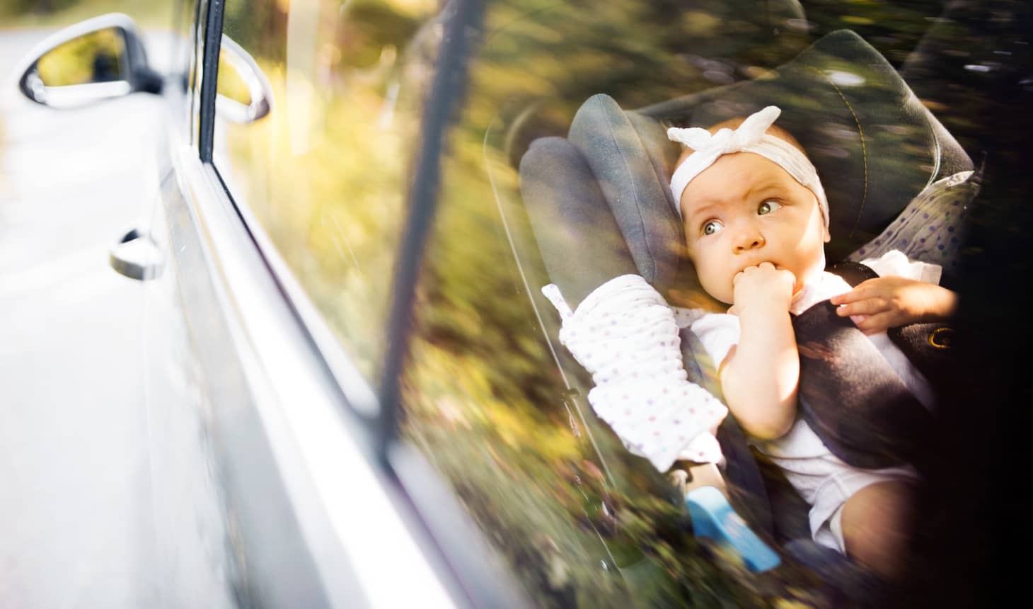 una bebé en el coche mirando por la ventana