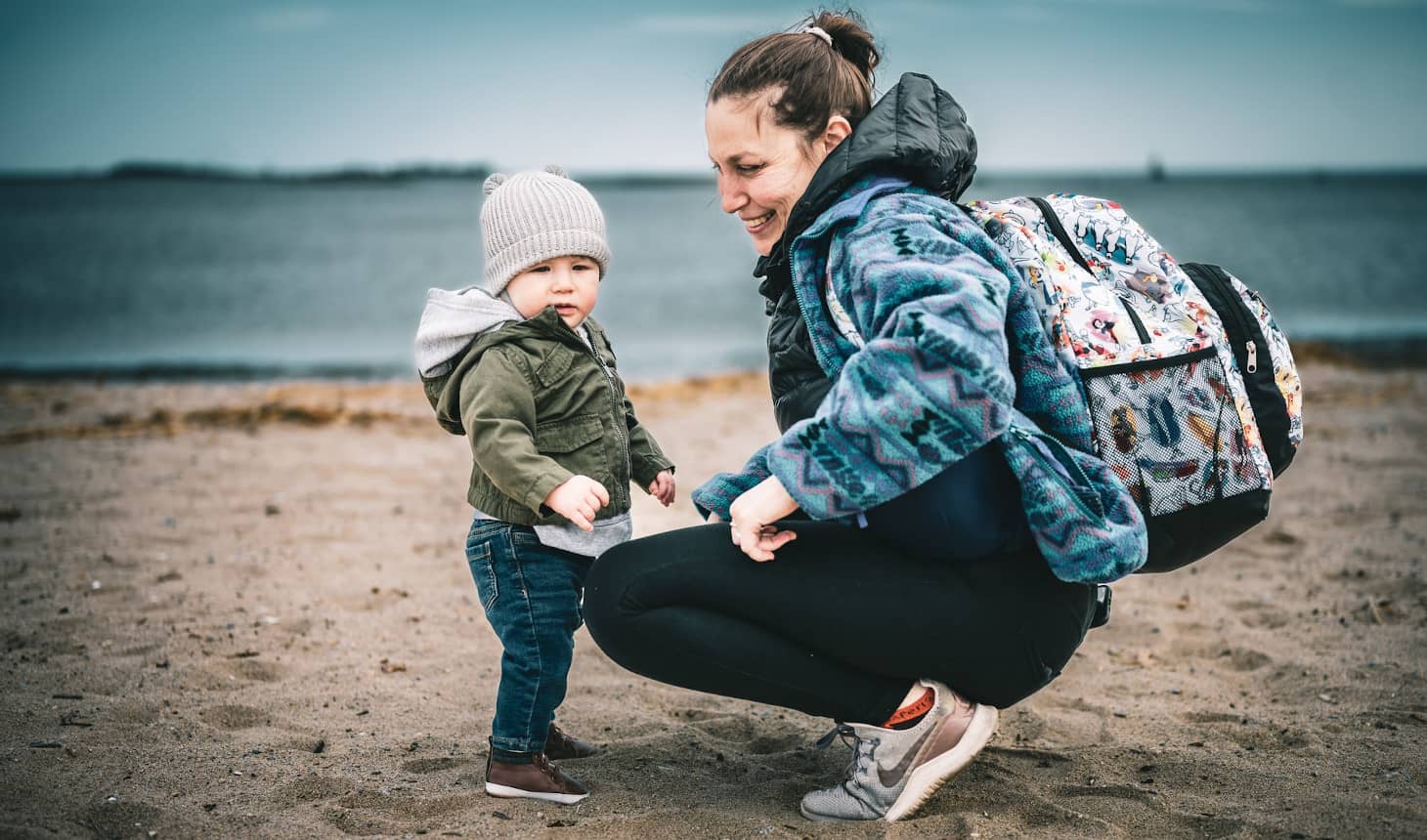 bebé abrigadito en la playa junto a su mamá