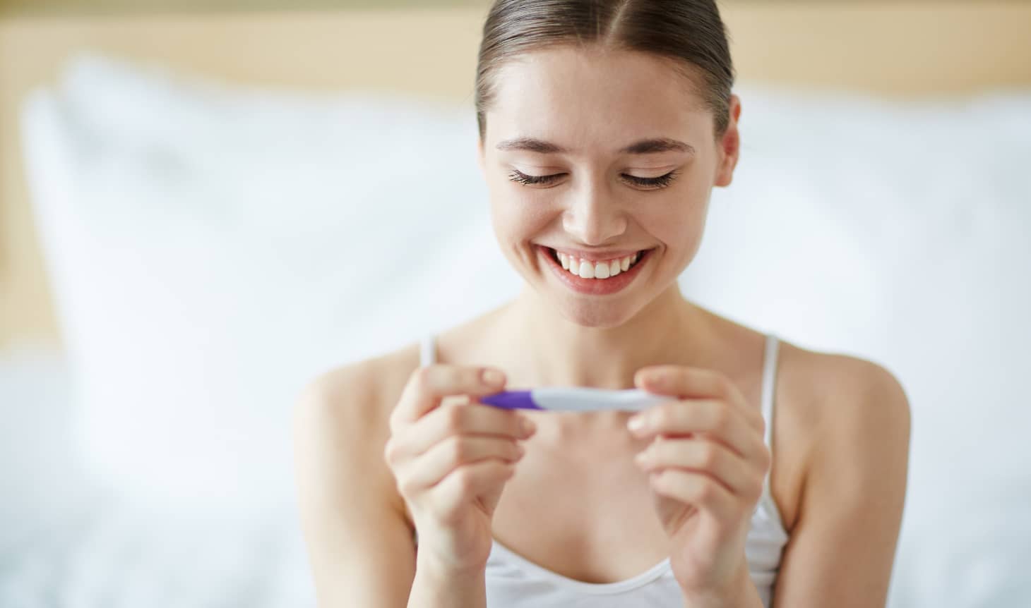 sonriendo al saber el resultado de un test de embarazo