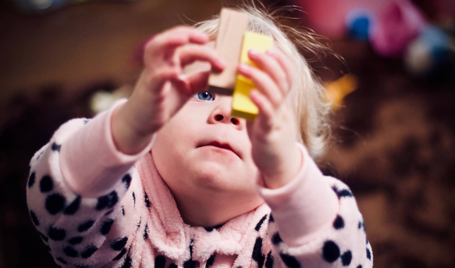 bebé levantando dos bloques de madera