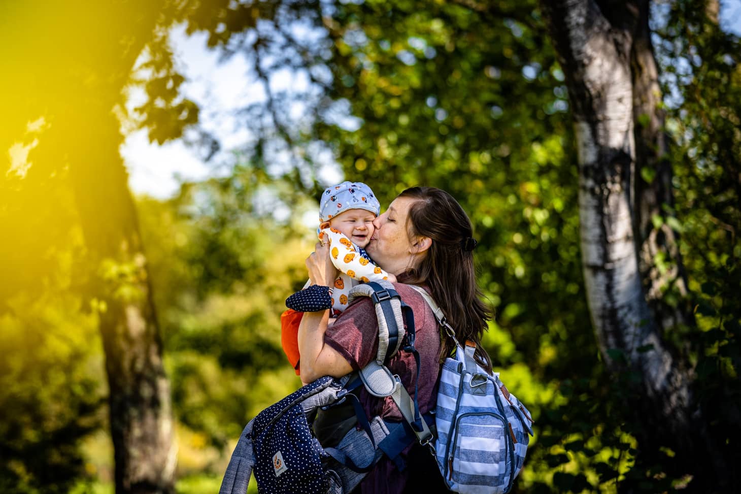 mamá cargada con mil cosas y con un bebé que quiere salir del portabebés