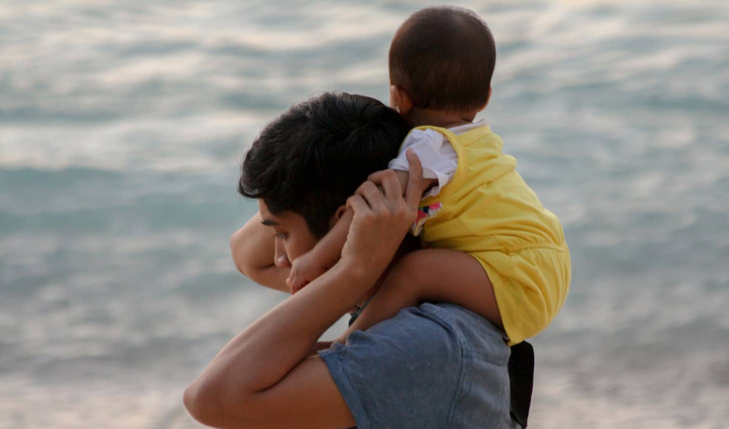 bebé vestido con ranita sobre los hombros de su hermano