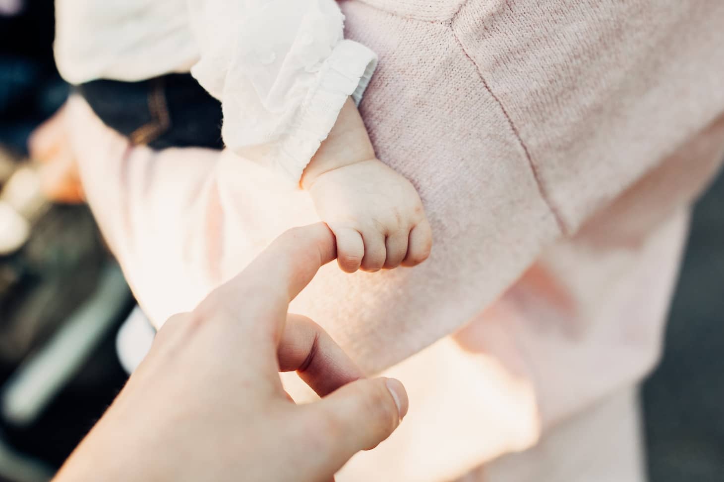 manita de bebé agarrando a su mamá