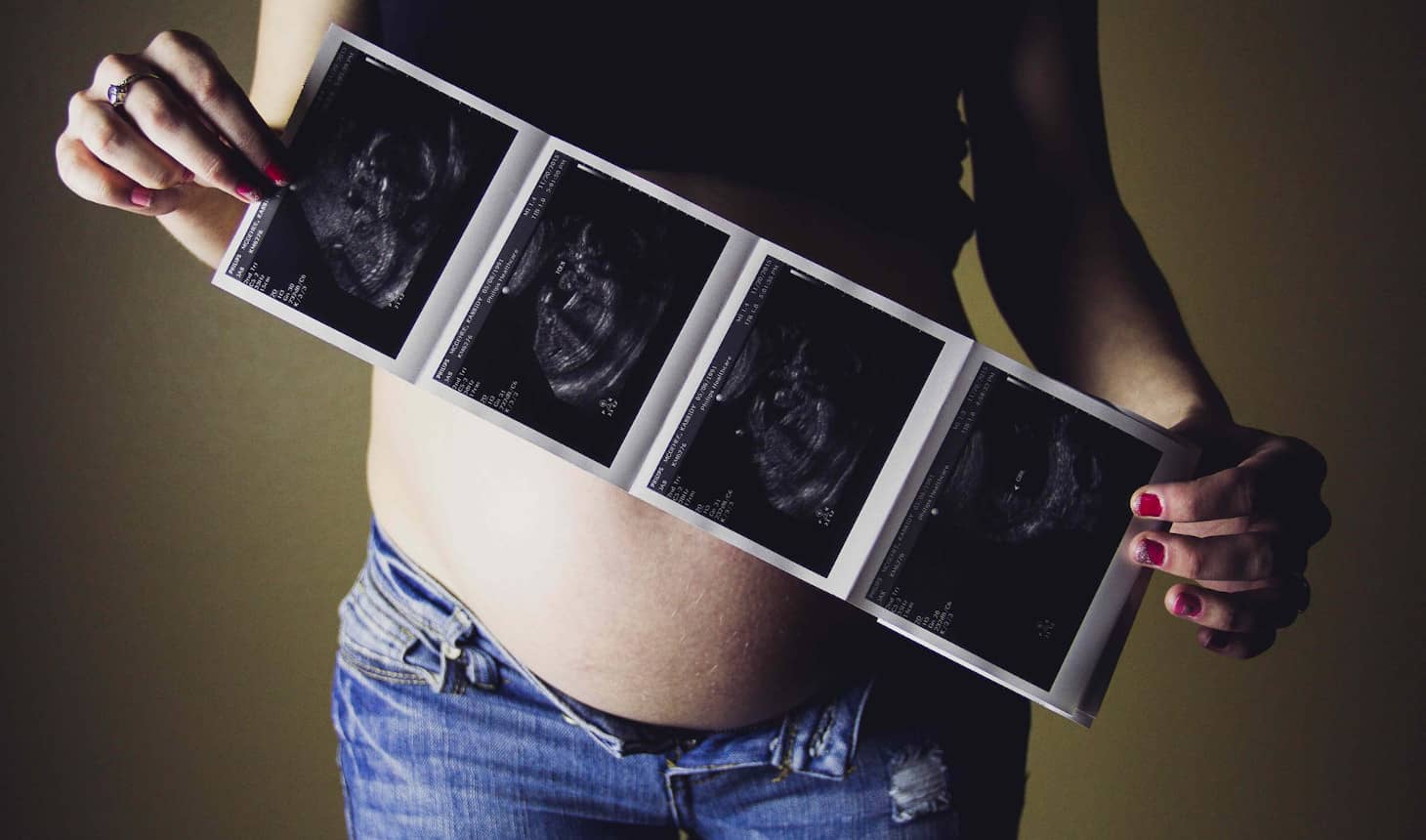 embarazada que muestra varias ecografías