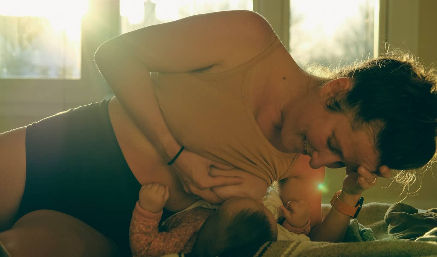 mamá que da de mamar con el bebé tendido