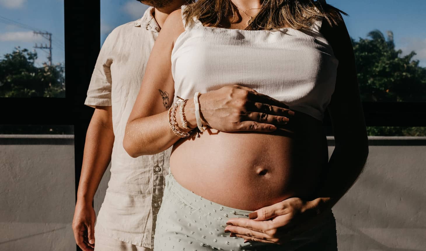 una mujer embarazada con un hombre al lado
