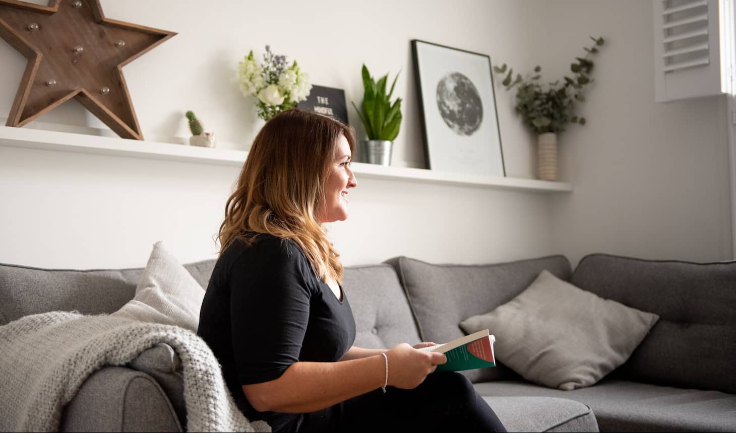 mujer leyendo sentada en el sofá