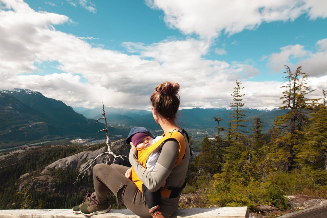 mamá mirando el paisaje con un bebé en un portabebés