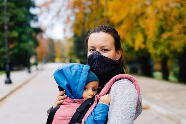 mujer con portabebés y mascarilla