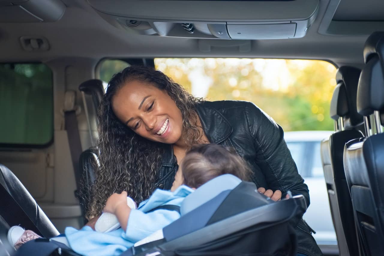 mamá sonriendo a su bebé en el coche