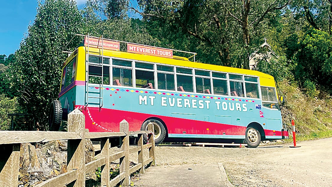 Positioned at the side of the road, a Mt Everest tour bus looks right at home amongst the mountainous Walhalla backdrop.
