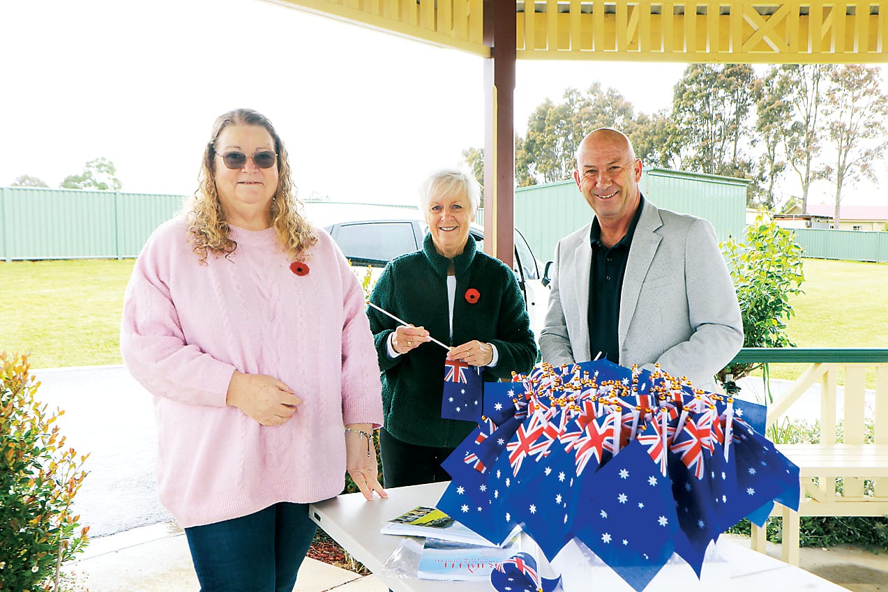 Preparing flags to place on graves of returned service men and women at Neerim Cemetery are Janeane Raymount, Chris Cumming and Member for Narracan Wayne Farnham.