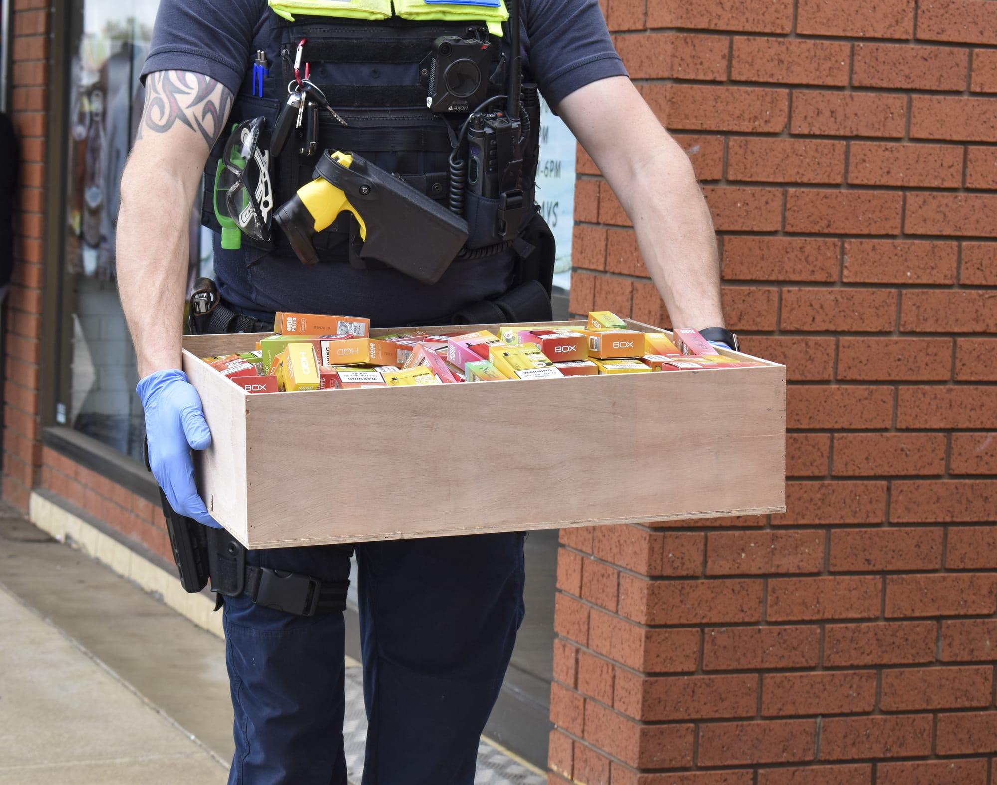 Senior constable Aaron Bowen carries a box of vapes.