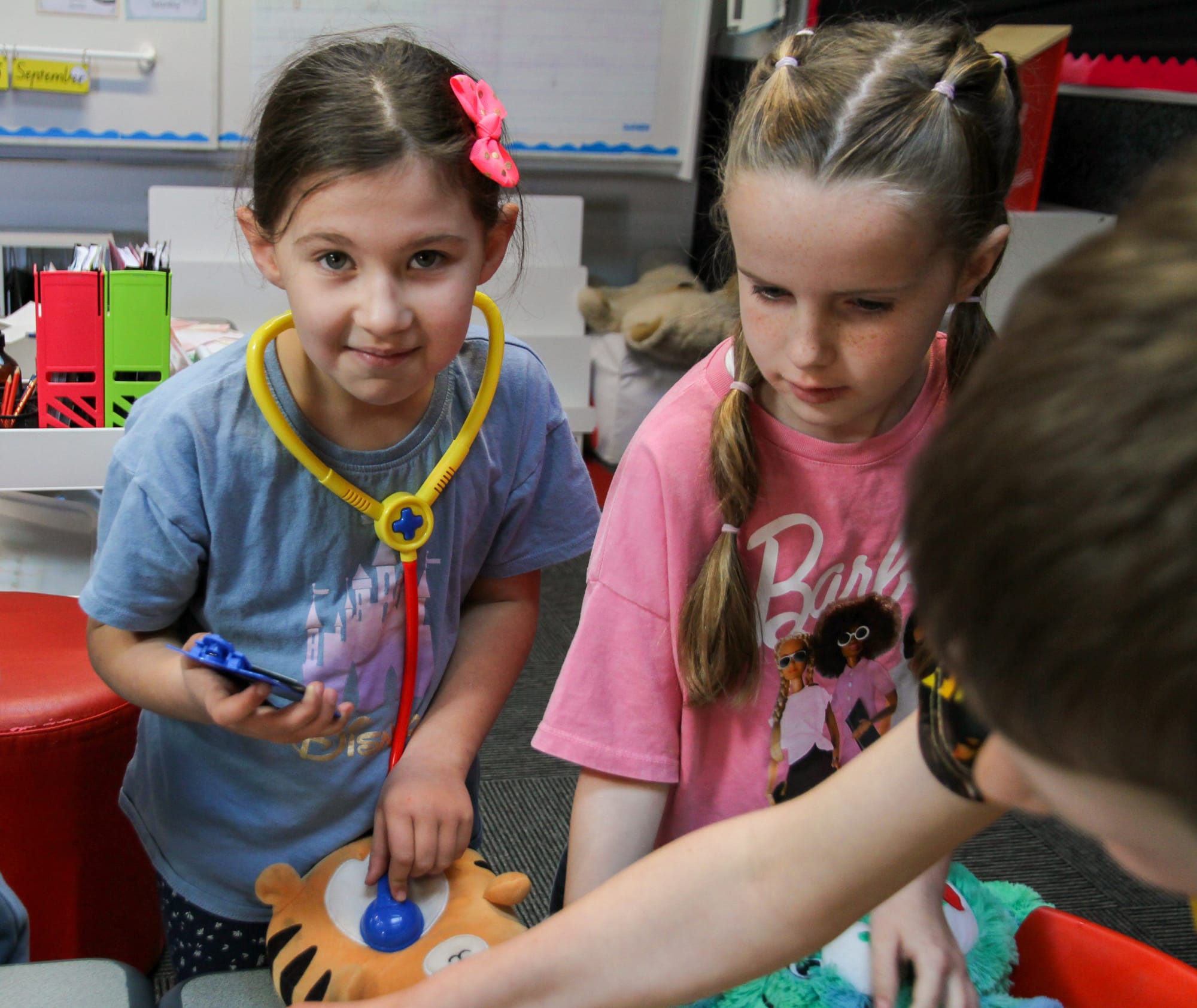 Tahlia Trenery and Tess Munro listen to the heartbeat of their teddy bear friends.