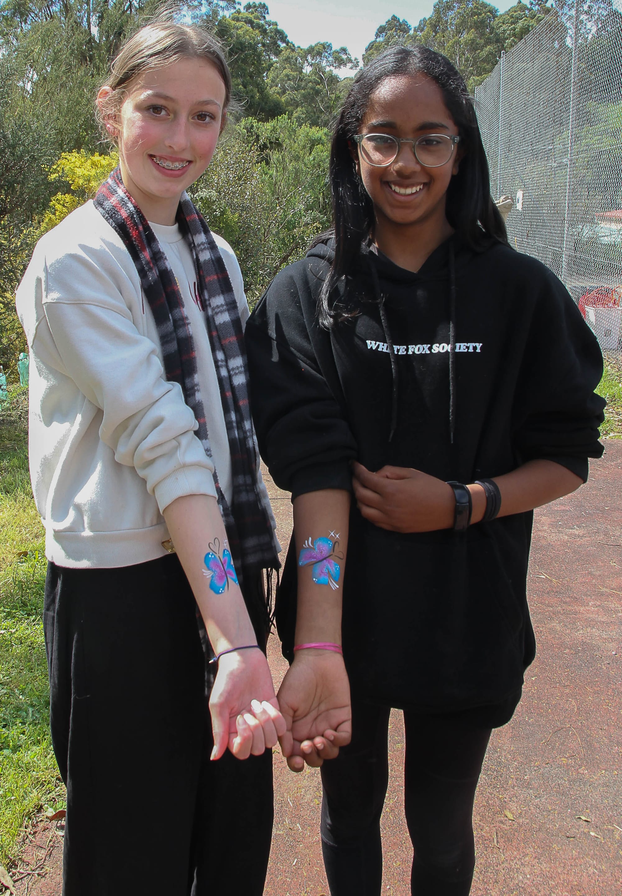 Locals Vanessa McDonald (left) and Maithya Armour opt for arm art instead of face painting.
