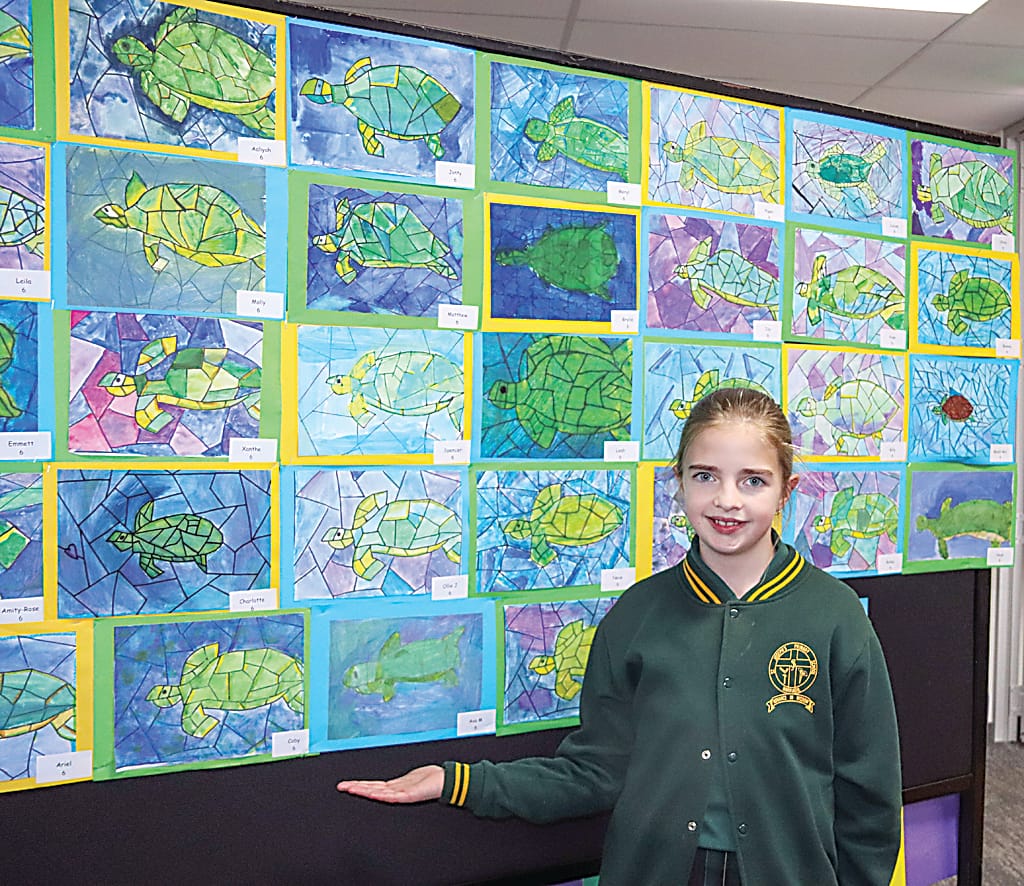 Left: Olivia shows off the wall of cubism style turtles. Olivia said she used a mix of chalk, pencil and water colour paints to create her work.Right: Packed with lots of brightly coloured shapes, Liv shows off the Mondrian inspired artwork.