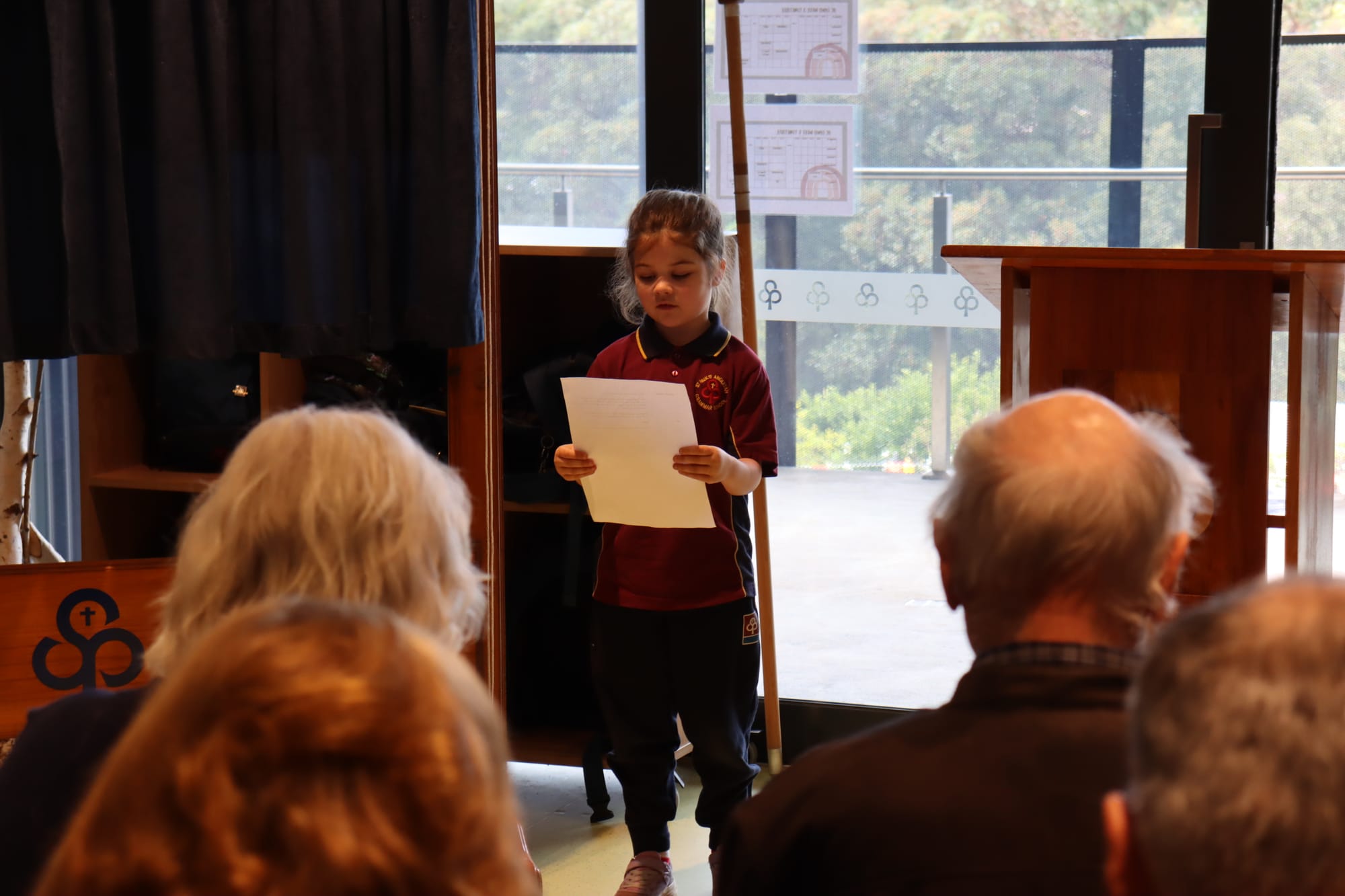 Junior school student Charlotte Wilson reads the school prayer aloud.
