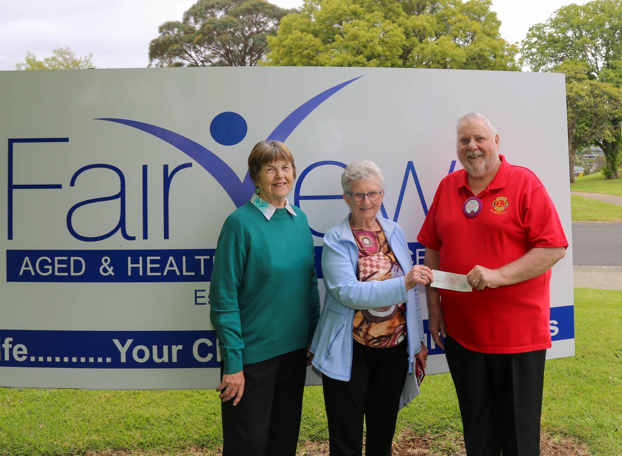 Fairview Village's Pauline Baker and Lorraine Winter present the $1851 cheque to Warragul Lions Club member Terry Hayler.