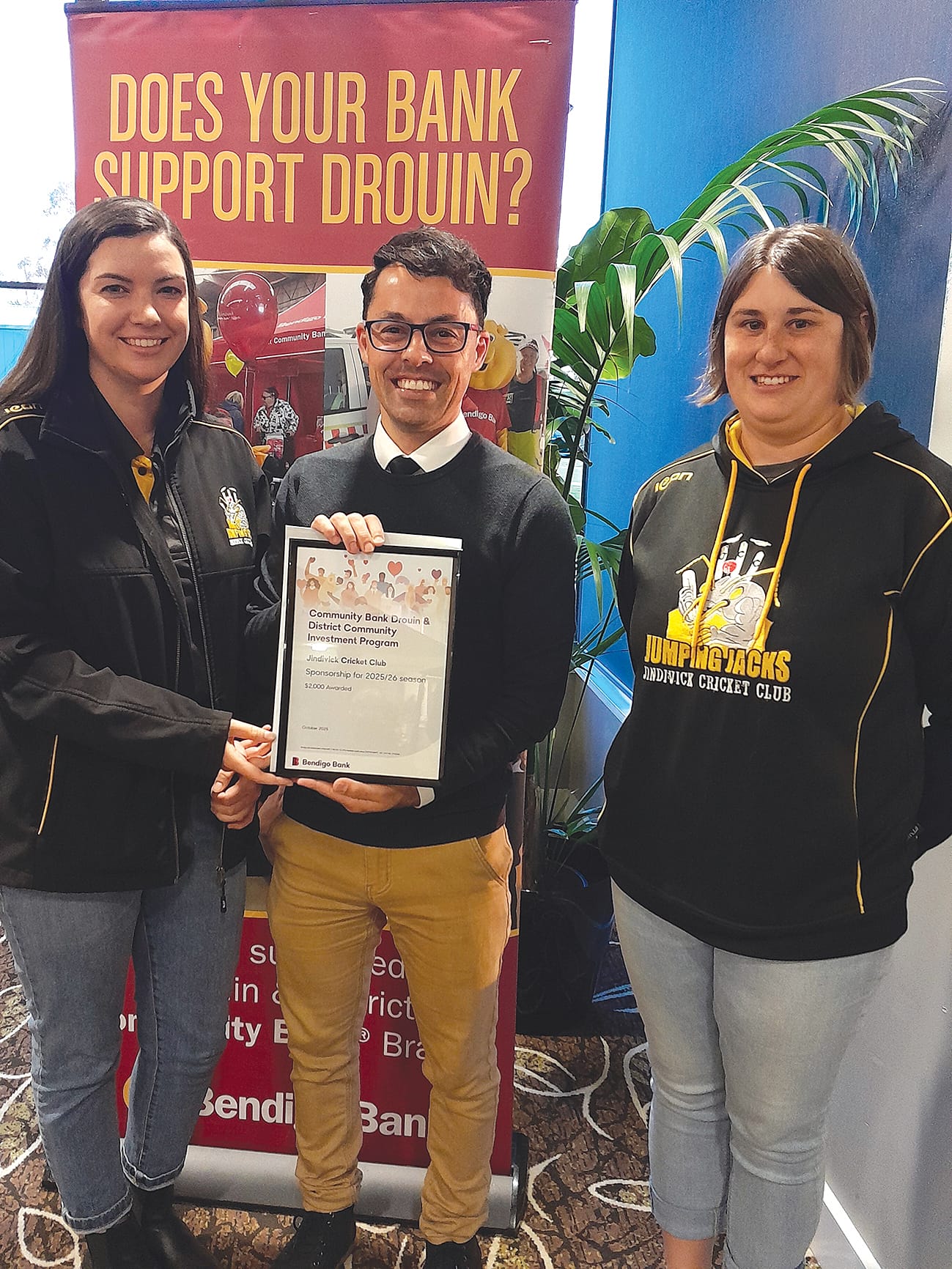 Bank director Shaun Mallia (centre) presents sponsorship to Jindivick Cricket Club representatives Jess Sanders and Lauren Burridge.