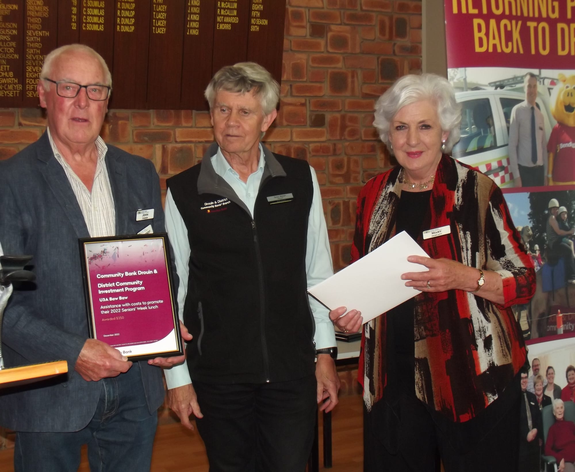 Drouin community bank director Sean Walsh (centre) presented funding to help meet the cost of the University of the Third Age Baw Baw's 18th literary lunch to John Parker and Mary Howlett.