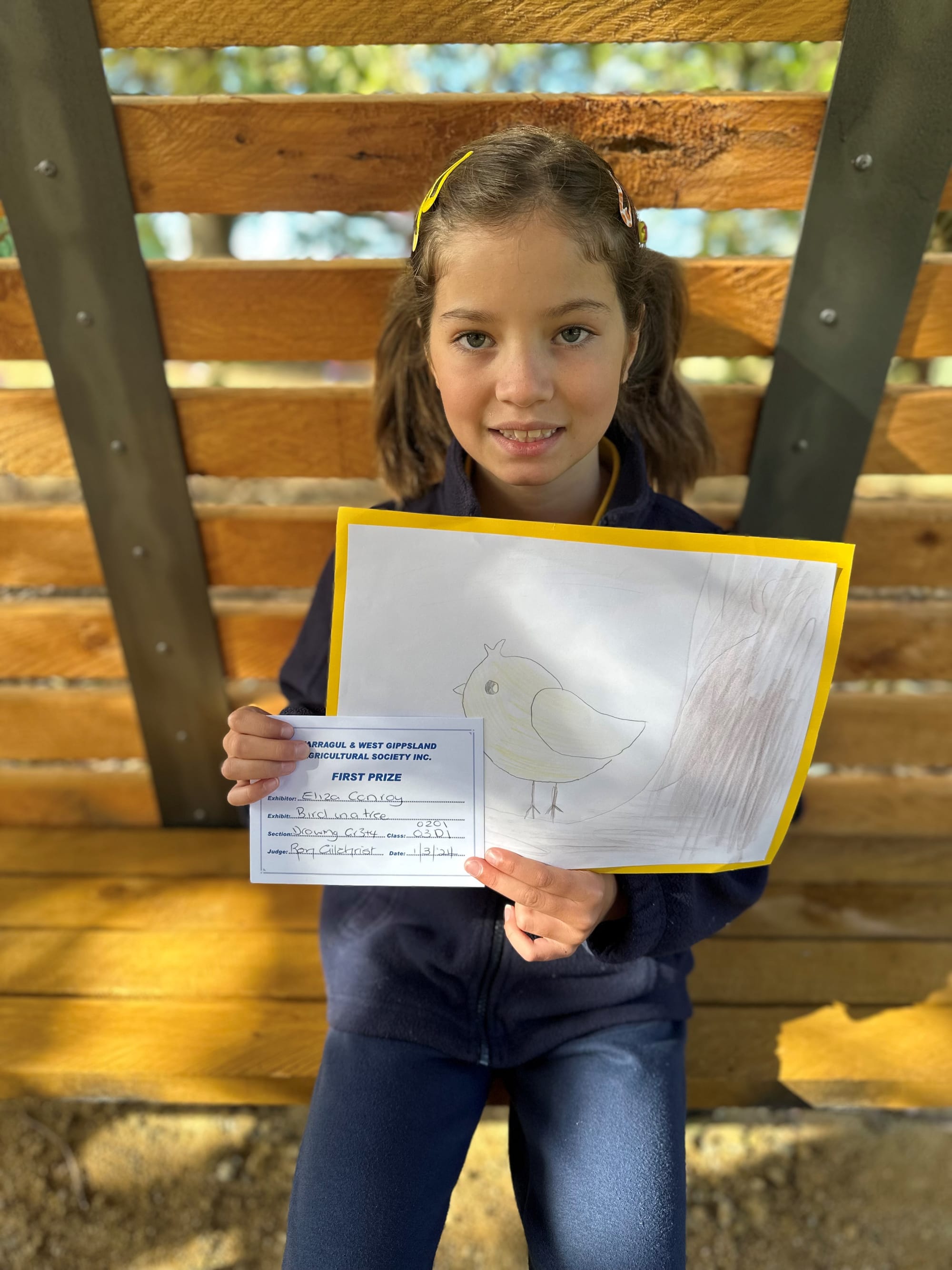 Showing off her first placed drawing his grade three student Eliza Conroy.