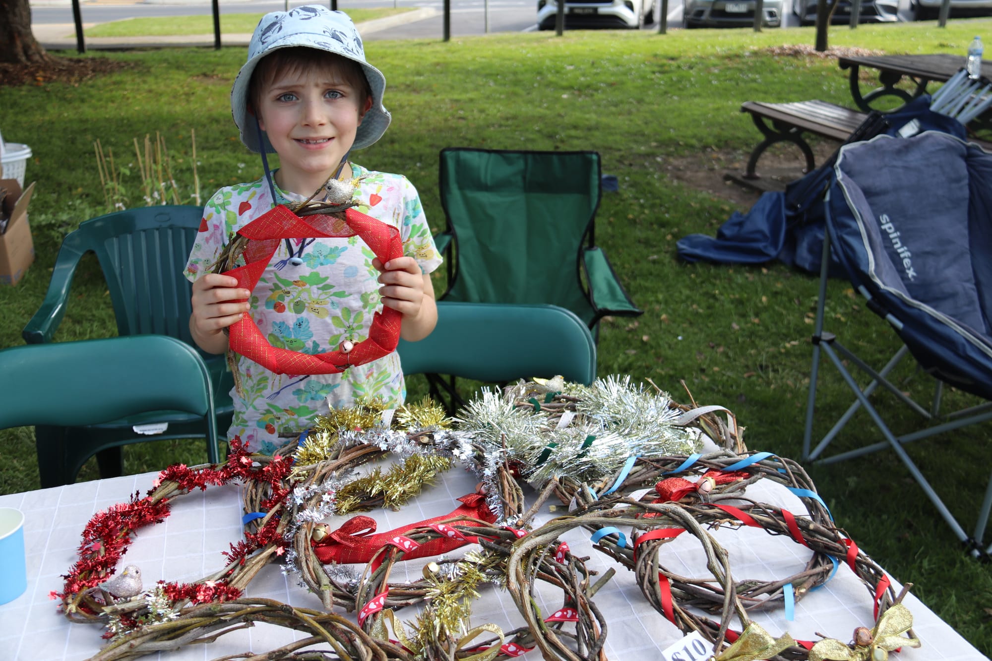 Seven-year-old Tom Brooker shows off the Christmas wreaths that he and sister Rose made for their market stall.