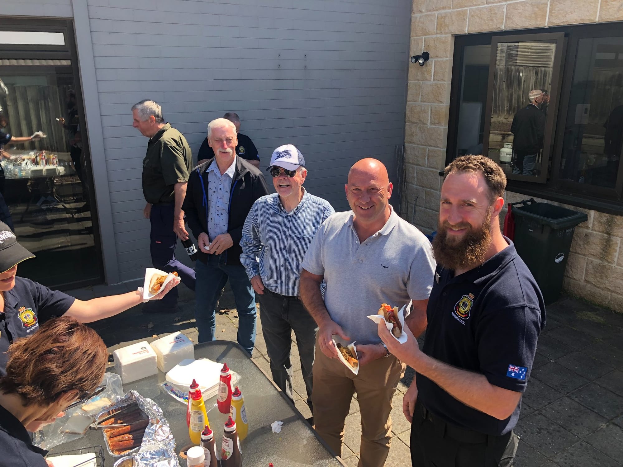 Wayne Farnham with attendees in the line for the sausage sizzle at the event.