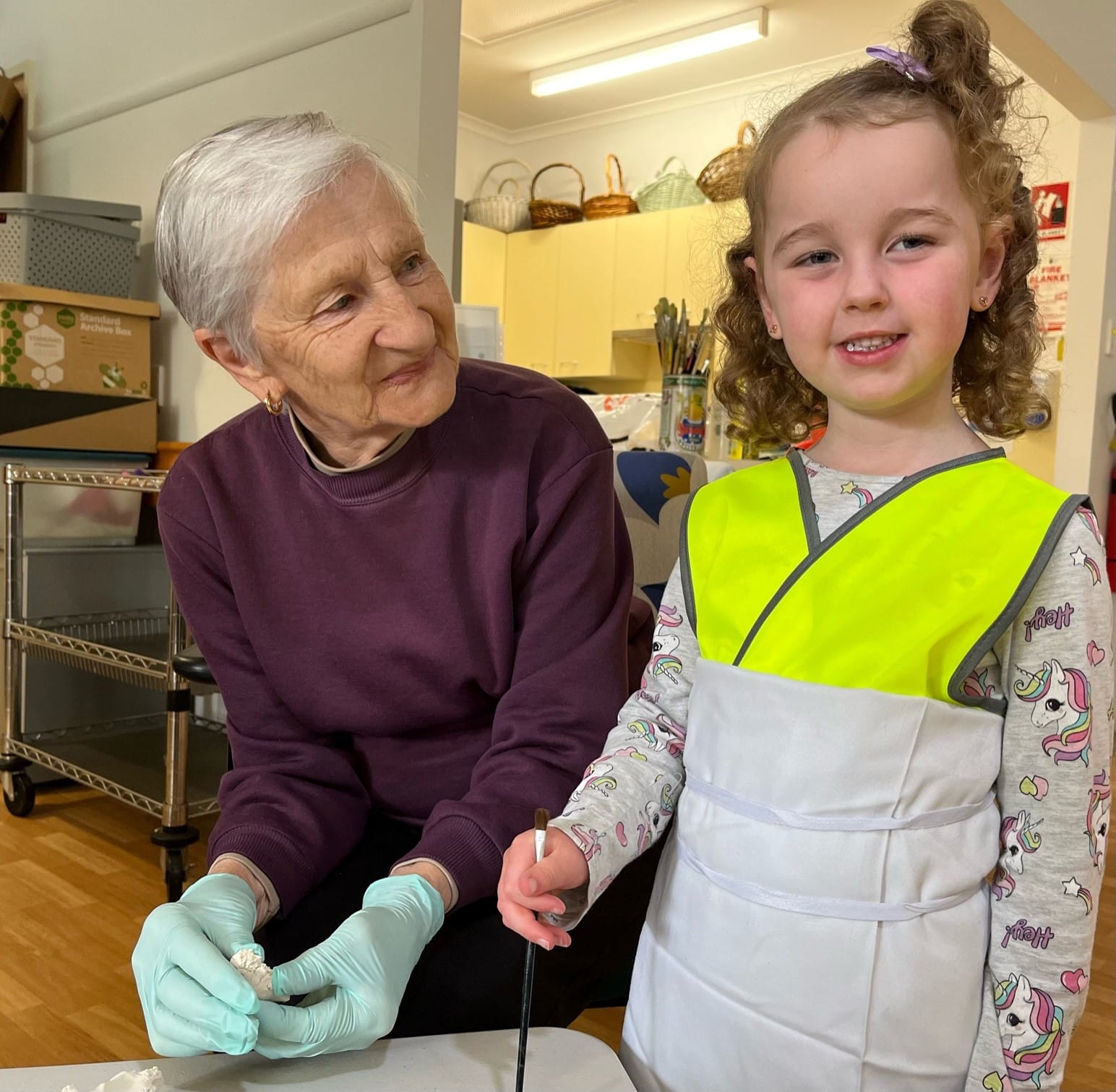 Andrew's House resident Val helps Avery create a clay Christmas tree during the Yarragon Children's Centre visit.