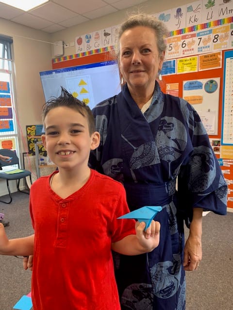 Student Payton Bowles enjoys origami with teacher Janet Poelsma.