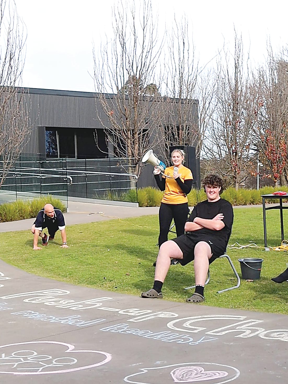 Above: Penny Matthews takes the lead on the megaphone while Benjamin Denton bravely waits to be drenched.Right: Huang (George) Hanting delivers a big freeze to St Paul's teacher Jake Sharp.