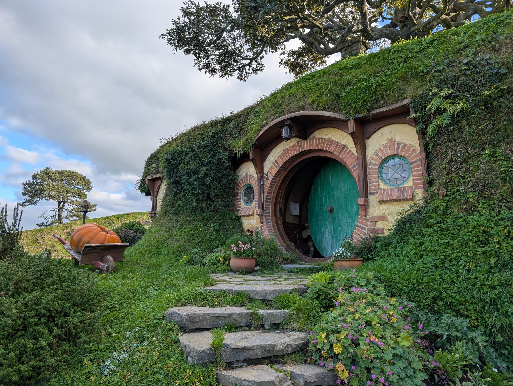 A round green door embedded into a hill