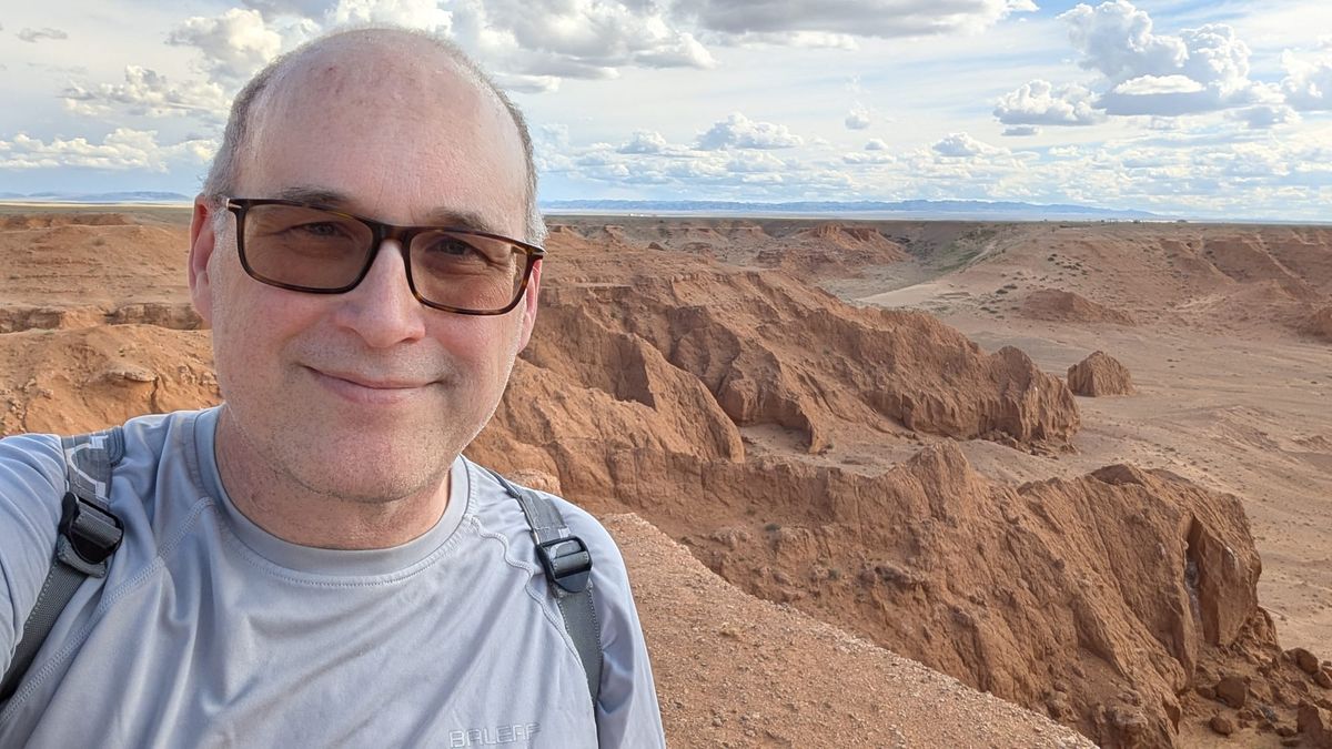 Me blocking the view of red cliffs in a desert