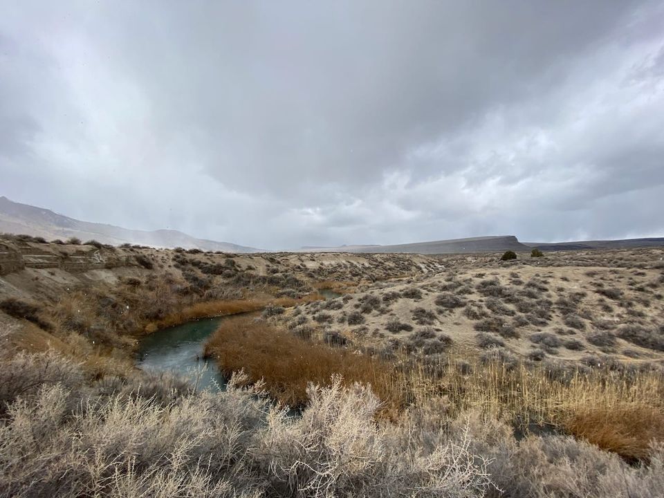 High desert landscape with a river and clouds.